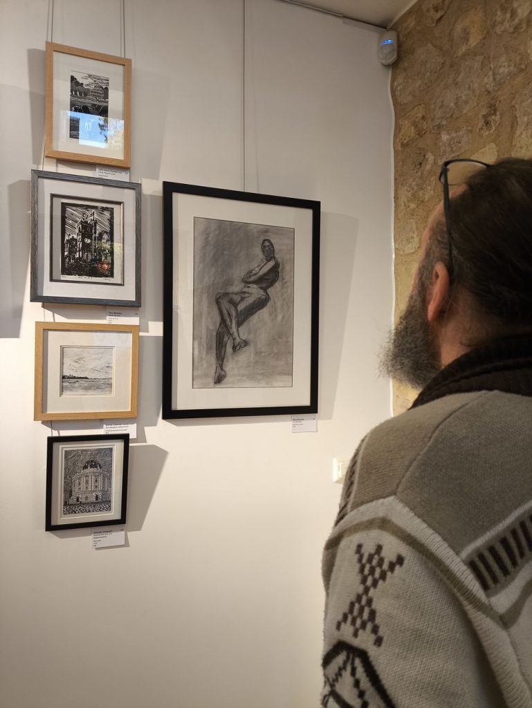 Someone is looking at the charcoal drawing You did what? exhibited at the Oxford art society open exhibition 2026